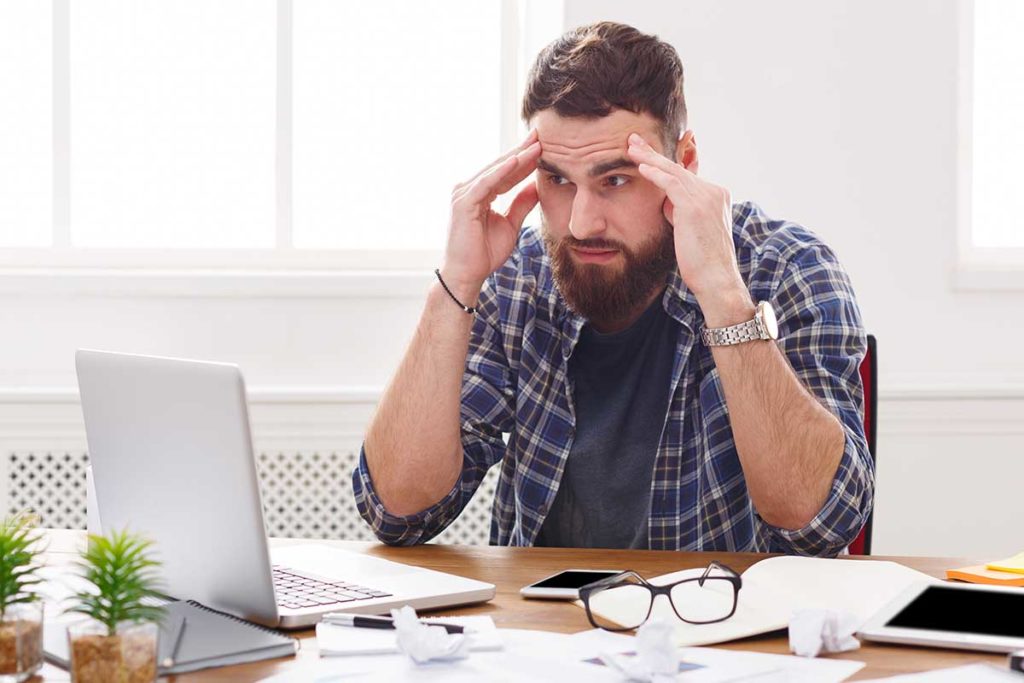 person stressed searching laptop for causes of addiction