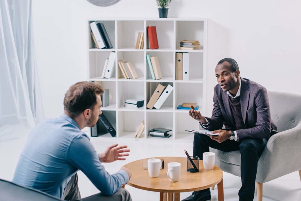 man talking to therapist in trauma therapy